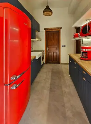 a red refrigerator in a kitchen with blue cabinets at BROWN ON GREEN a stone house with amazing view in Drapaniás