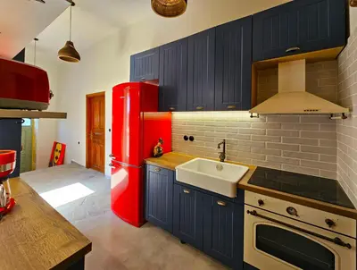 a kitchen with a red refrigerator and a sink at BROWN ON GREEN a stone house with amazing view in Drapaniás