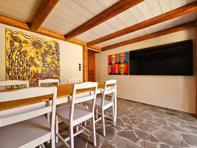 a conference room with a table and chairs and a screen at BROWN ON GREEN a stone house with amazing view in Drapaniás