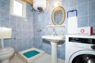 a bathroom with a sink and a washing machine at Galatas Maisonette in Galatás