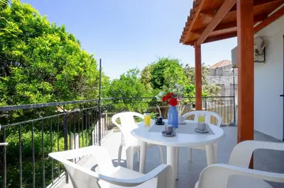 a white table and chairs on a balcony at Galatas Maisonette in Galatás