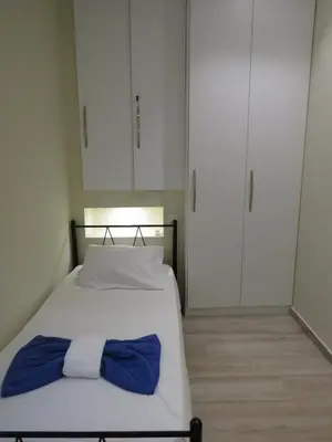 a bed with a blue and white bow tie on it at Cosy apartment in Koum Kapi Beach in Chania Town