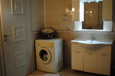 a bathroom with a washing machine and a sink at Stone House by the Sea in Tavronitis