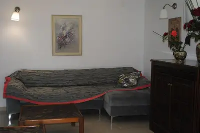 a bedroom with a bed and a dresser and a table at Stone House by the Sea in Tavronitis