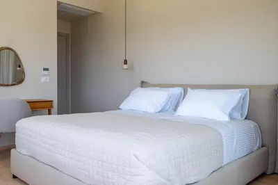 a white bed with white sheets and pillows on it at Ataraxia Villa in Spiliá