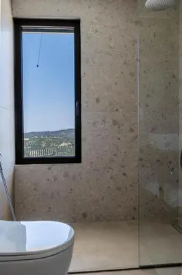a bathroom with a toilet and a window at Ataraxia Villa in Spiliá