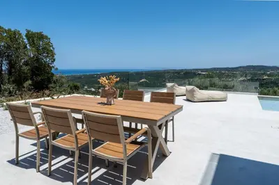 a wooden table and chairs on a patio at Ataraxia Villa in Spiliá