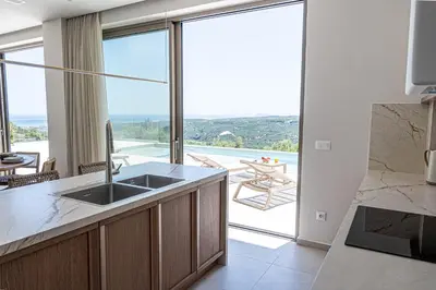 a kitchen with a sink and a view of a patio at Ataraxia Villa in Spiliá