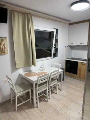 a kitchen with a white table and chairs in a room at Villa Dadis in Chania