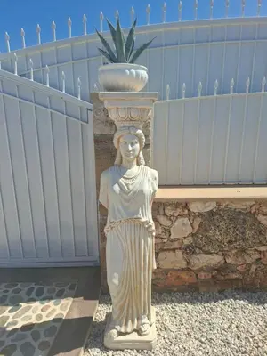 a statue of a woman standing next to a fence at Villa Dadis in Chania