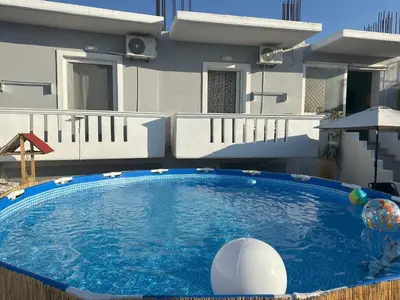 a large swimming pool in front of a house at Vila Alexandros in Souda