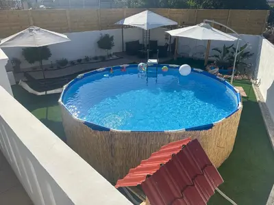 a large swimming pool with a large wooden tub at Vila Alexandros in Souda