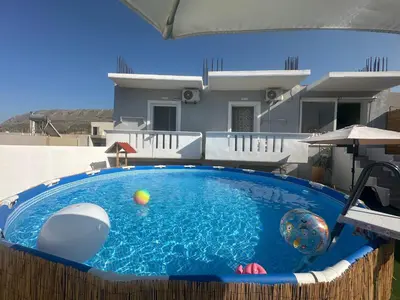 a swimming pool with balls in the middle of a house at Vila Alexandros in Souda