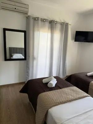 a hotel room with two beds and a mirror at Serenity apartment sea view in Souda