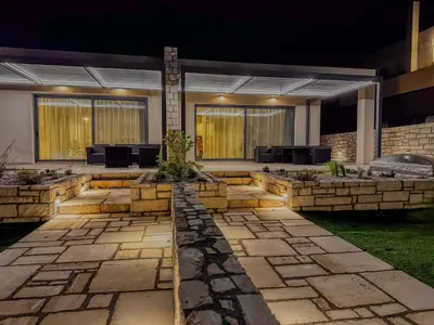 a house with a stone walkway in front of it at Gialos Villas Paleochora in Palaiochóra