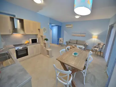 a kitchen and living room with a table and chairs at Niriides Apartments in Kissamos