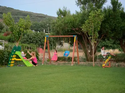 a group of children playing on a playground at Niriides Apartments in Kissamos