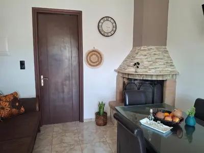 a living room with a fireplace and a couch at Casa Ioanna - Elegant Residence in Kalivianí