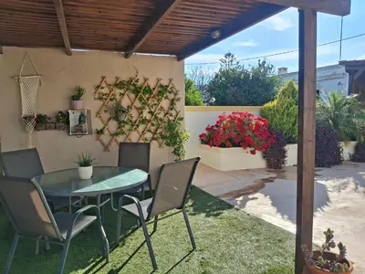 a patio with a table and chairs and flowers at Casa Ioanna - Elegant Residence in Kalivianí