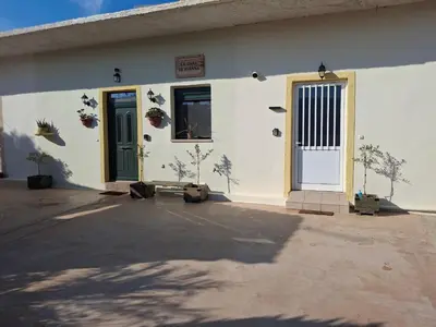 a white building with a door and plants on it at Casa Ioanna - Elegant Residence in Kalivianí