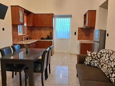 a kitchen and living room with a table and a couch at Casa Ioanna - Elegant Residence in Kalivianí