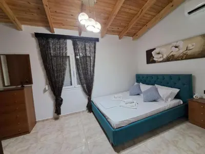 a bedroom with a blue bed in a room at Casa Ioanna - Elegant Residence in Kalivianí