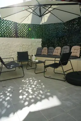 a group of chairs and a table with an umbrella at Casa di Keti in Chania Town