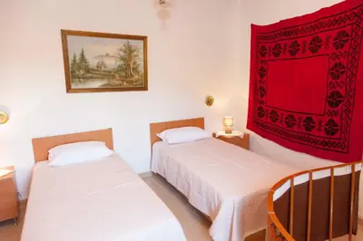 two beds in a room with a red blanket on the wall at Villa Olea-Renieri in Grigorianá