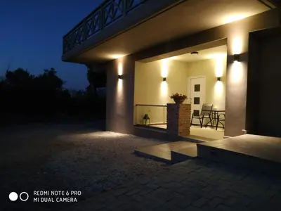 a night view of a house with lights on a patio at Evan's place in Chorafakia