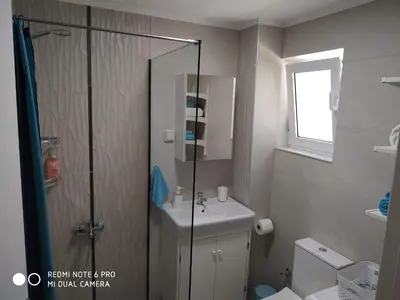 a bathroom with a shower and a sink and a toilet at Evan's place in Chorafakia
