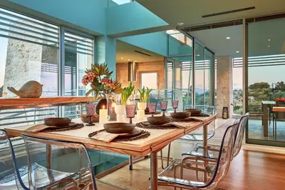 a dining room with a long wooden table with chairs at New Luxury Olives & Thyme Retreat, Seaview with 2 Heated Pools in Chania Town