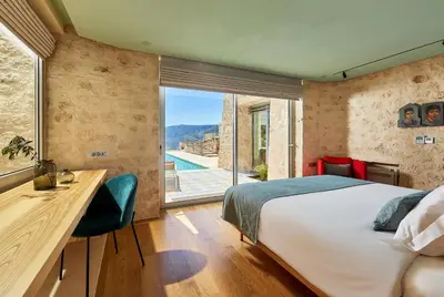 a bedroom with a bed and a desk and a window at New Luxury Olives & Thyme Retreat, Seaview with 2 Heated Pools in Chania Town