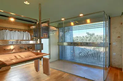 a bathroom with a glass shower and a wooden table at New Luxury Olives & Thyme Retreat, Seaview with 2 Heated Pools in Chania Town