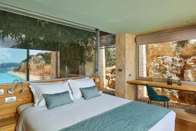 a bedroom with a bed and large windows at New Luxury Olives & Thyme Retreat, Seaview with 2 Heated Pools in Chania Town