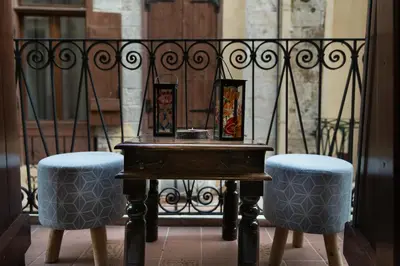 a table and two stools in front of a fence at Dream Art Studios in Chania Town