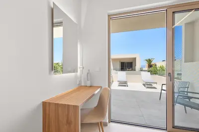 a living room with a wooden table and a balcony at Sea Princessa Villa in Chania Town