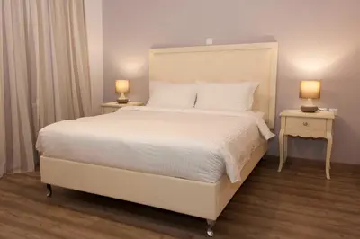 a bedroom with a large white bed with two night stands at Shalom Luxury Rooms Kondilaki in Chania Town