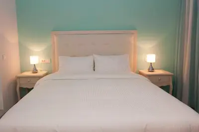 a bedroom with a large white bed with two lamps at Shalom Luxury Rooms Kondilaki in Chania Town
