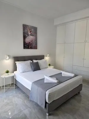 a bedroom with a large bed and a white wall at Olive Angel 1 in Chania Town
