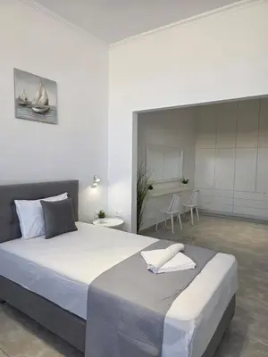 a bedroom with a large bed and a dining room at Olive Angel 1 in Chania Town