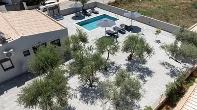 an overhead view of a swimming pool with trees at Glafkos house with pool near the beach in Daratso