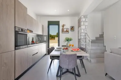 a kitchen and dining room with a table and a couch at Villa Meraki in Stalos
