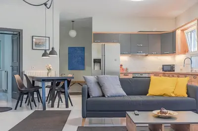 a living room and kitchen with a couch and a table at Sylvie Comfort Living in Chania Town