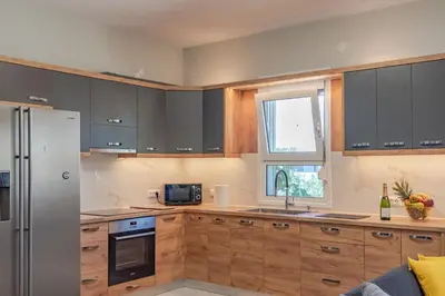 a kitchen with wooden cabinets and a stainless steel refrigerator at Sylvie Comfort Living in Chania Town