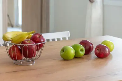 a basket of fruit on a table with apples and bananas at Garden House 2 in Kissamos