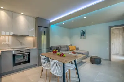 a kitchen and living room with a table and a couch at Garden House 2 in Kissamos
