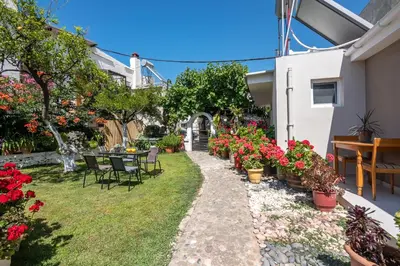 a garden with flowers and a table and chairs at Garden House 2 in Kissamos