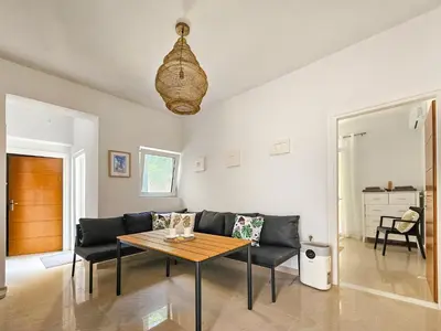 a living room with a couch and a table at Dafne Almyrida Beach Apartment in Almirida