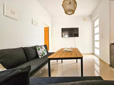 a living room with a couch and a wooden table at Dafne Almyrida Beach Apartment in Almirida