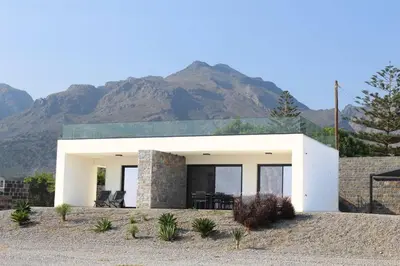 a white house with mountains in the background at Astrokastro Frangokastello in Frangokastello
